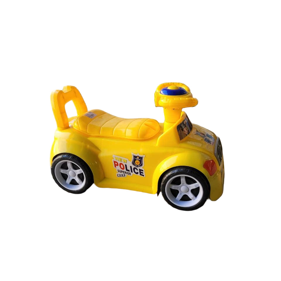 Yellow toy police car on a concrete floor with a television screen displaying children's content in the background.