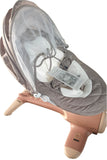 Baby swing with a mesh cover on a concrete floor