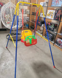 Colorful children's swing set in a store setting with toys on shelves.
