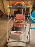 Children's swing set with colorful design and toys on a stand.