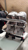 Double stroller with two seats on a white surface