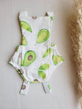 Baby onesie with avocado pattern on a light wooden surface