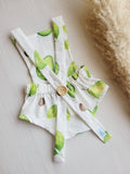 Baby romper with avocado print on a neutral background
