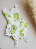 Baby outfit with avocado pattern on a light surface