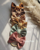 Set of five fabric bows in different colors with labels on a light background
