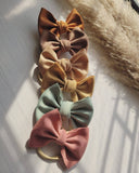 Set of colorful hair bows on a textured surface