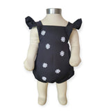 Black romper with white floral patterns on a mannequin against a white background