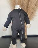 Black onesie with a zipper on a mannequin against a neutral background