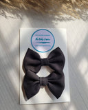2 Black bow clips on a card 
